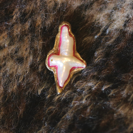 A brooch made of bronze, pearl and resin