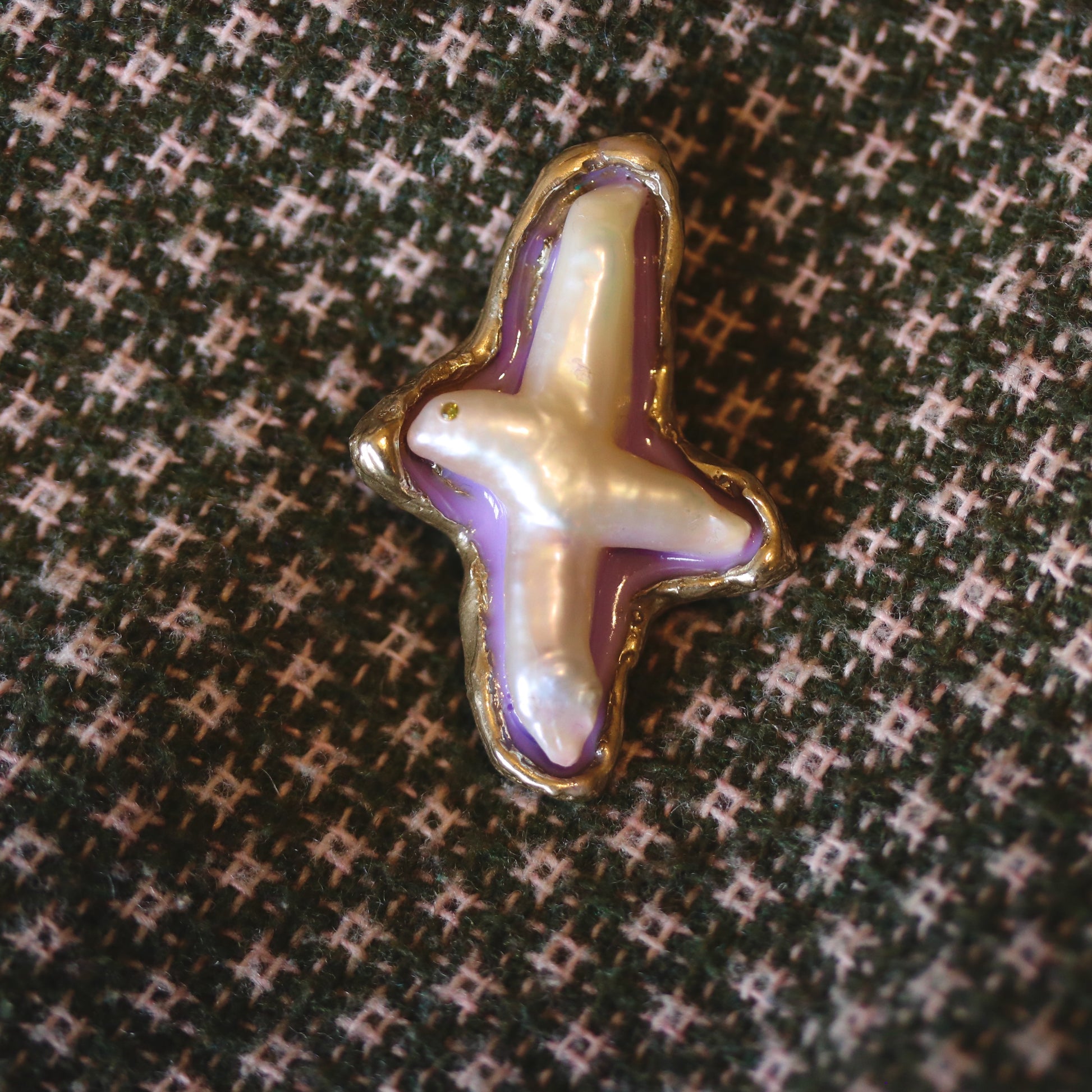 A handmade brooch of bronze, pearl and resin