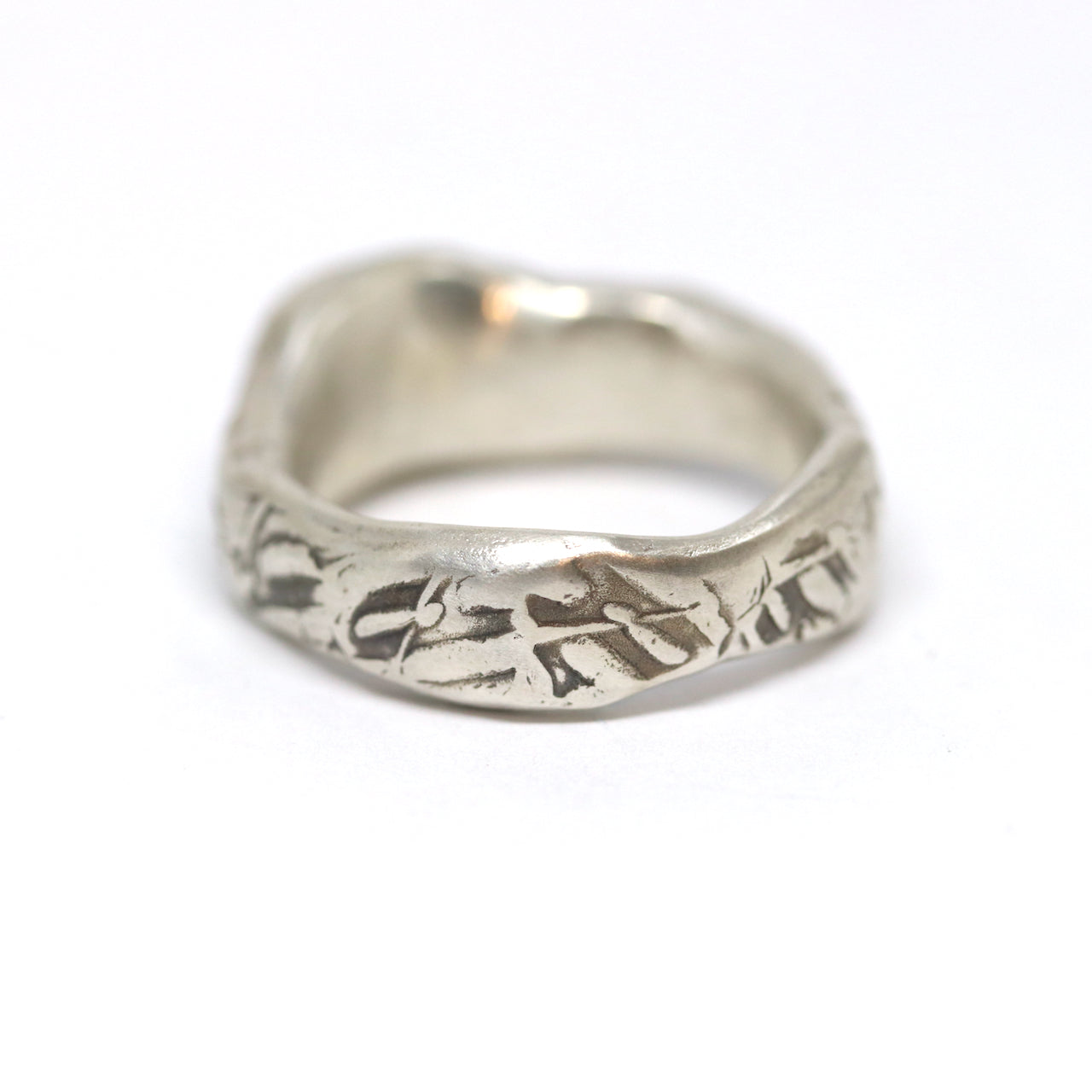 A curvy and chunky sterling silver with textured oxidised silver. This pattern was imprinted into the wax before casting. The ring is set with one oval olive green cubic zirconia.