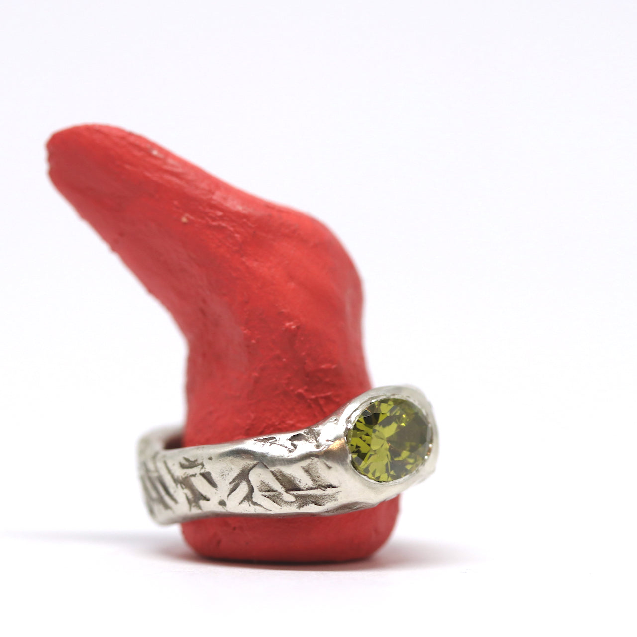 A curvy and chunky sterling silver with textured oxidised silver. This pattern was imprinted into the wax before casting. The ring is set with one oval olive green cubic zirconia.