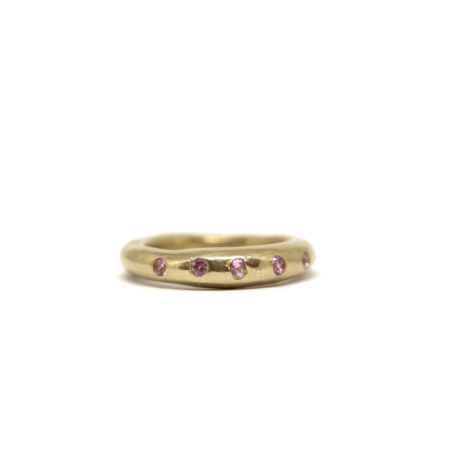 Bronze ring with pink gemstones on a white background