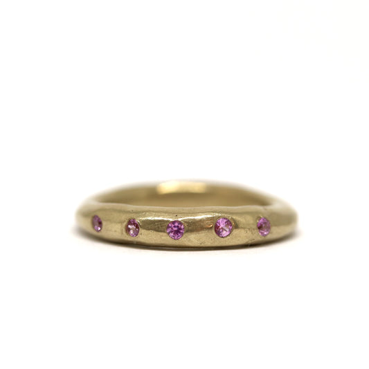Bronze ring with pink gemstones on a white background