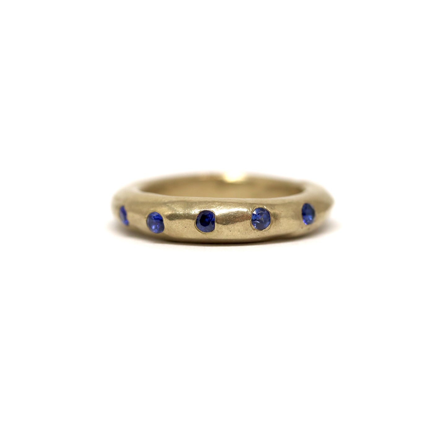 Bronze ring with dark blue gemstones on a white background