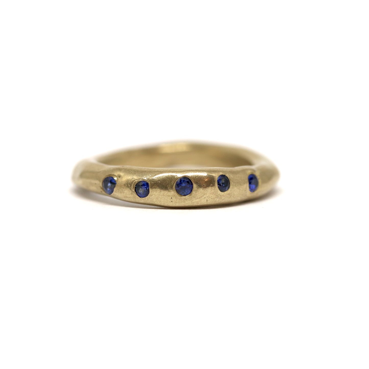 Bronze ring with dark blue gemstones on a white background
