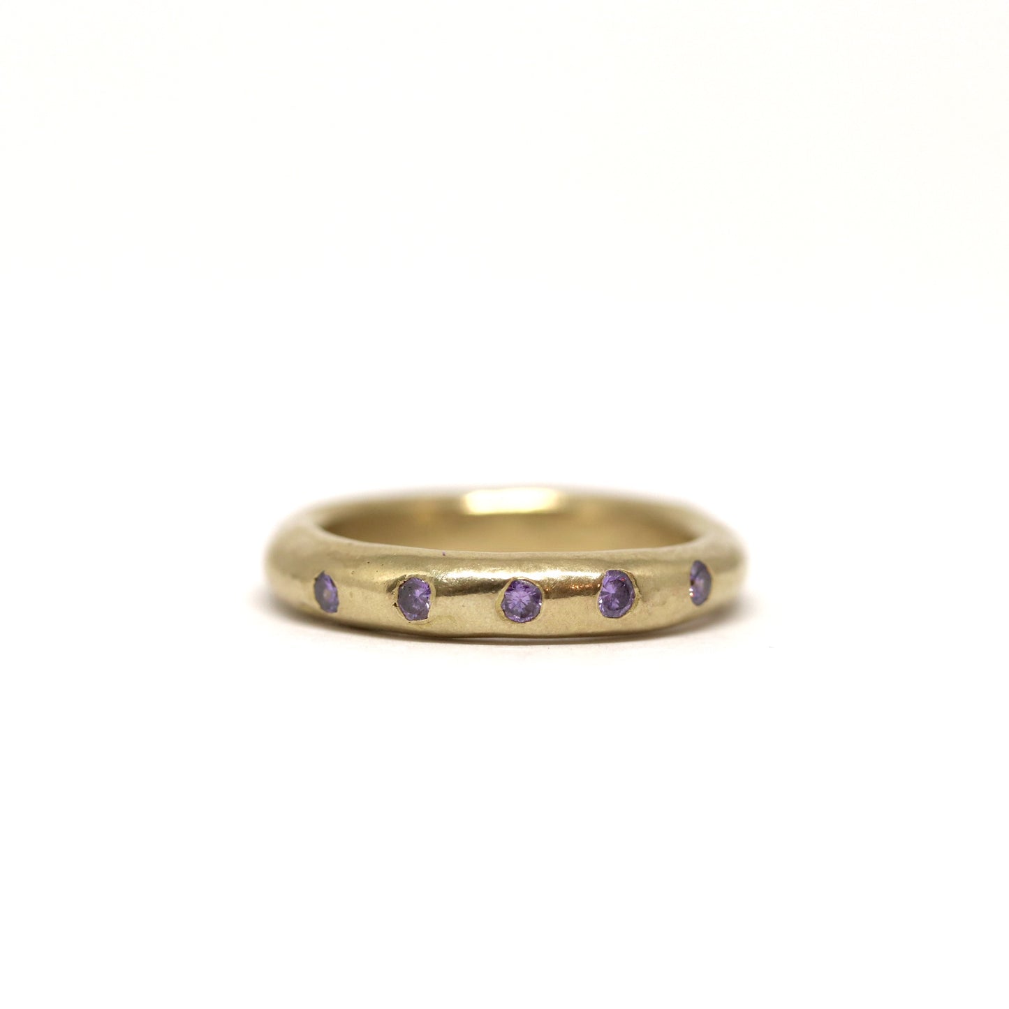 Bronze ring with purple gemstones on a white background