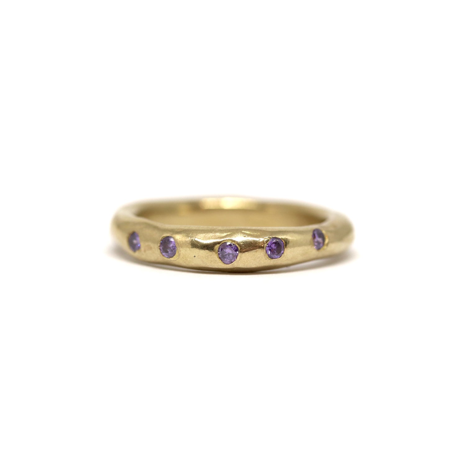 Bronze ring with purple gemstones on a white background