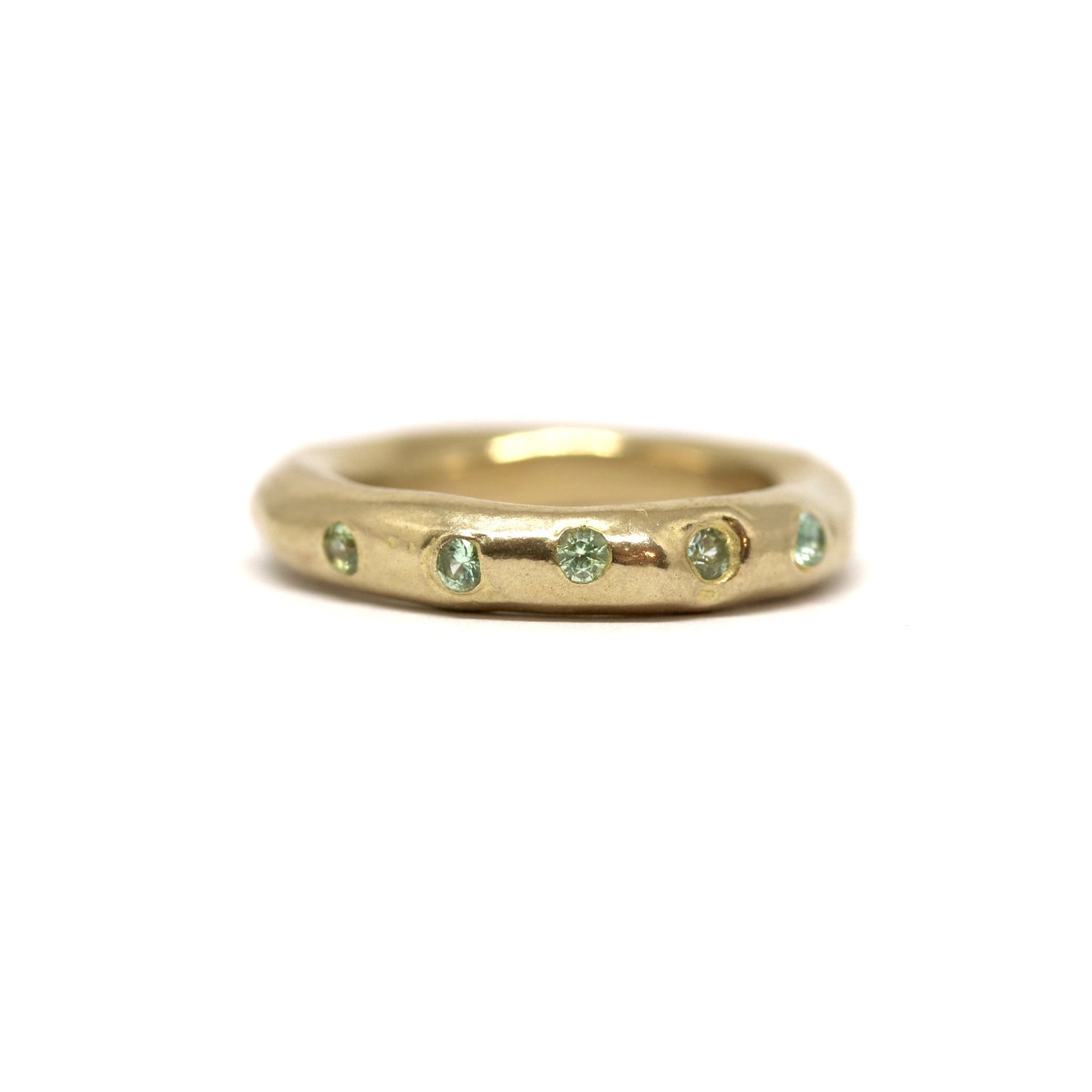 Bronze ring with green gemstones on a white background