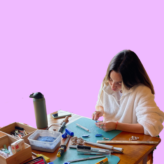 Woman at table surrounded by tools making a ring