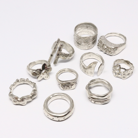 Collection of various silver rings on a white background