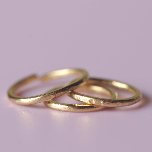 A pile of three 22 ct gold nose rings made by Fruit Bowl Studio, Wānaka, New Zealand.