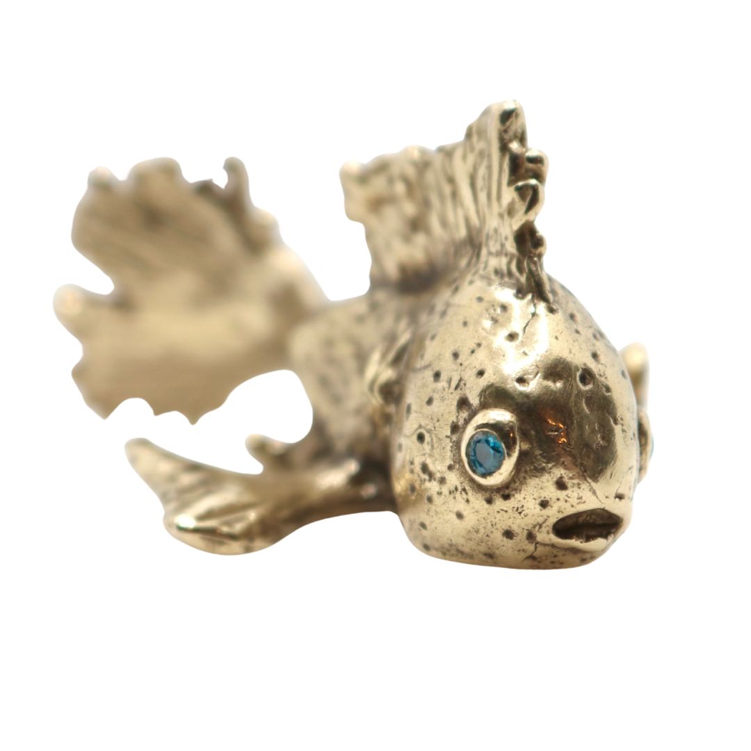 Bronze fish sculpture with a blue eye on a white background