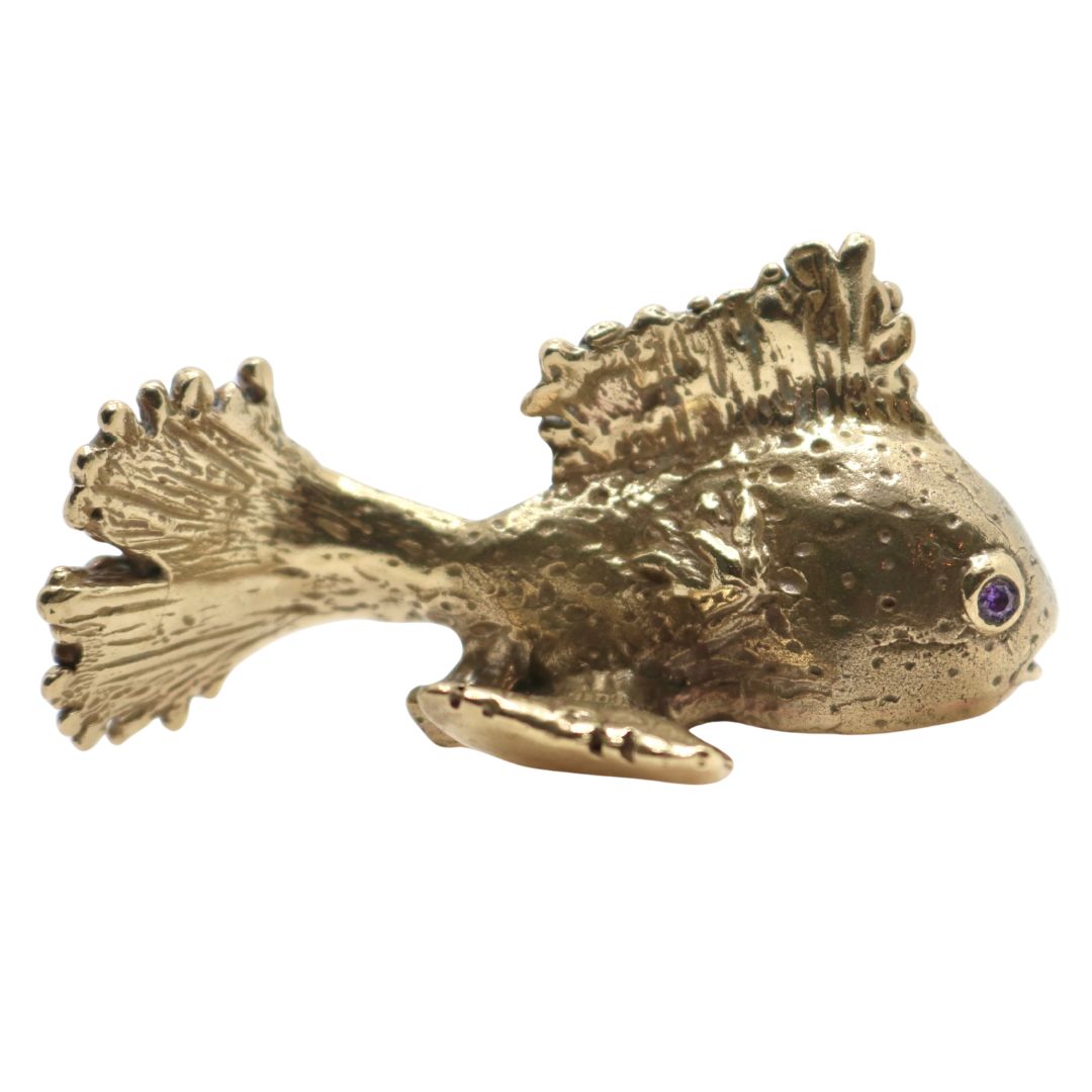 Bonze Gold fish sculpture with a purple gemstone eyes on a white background