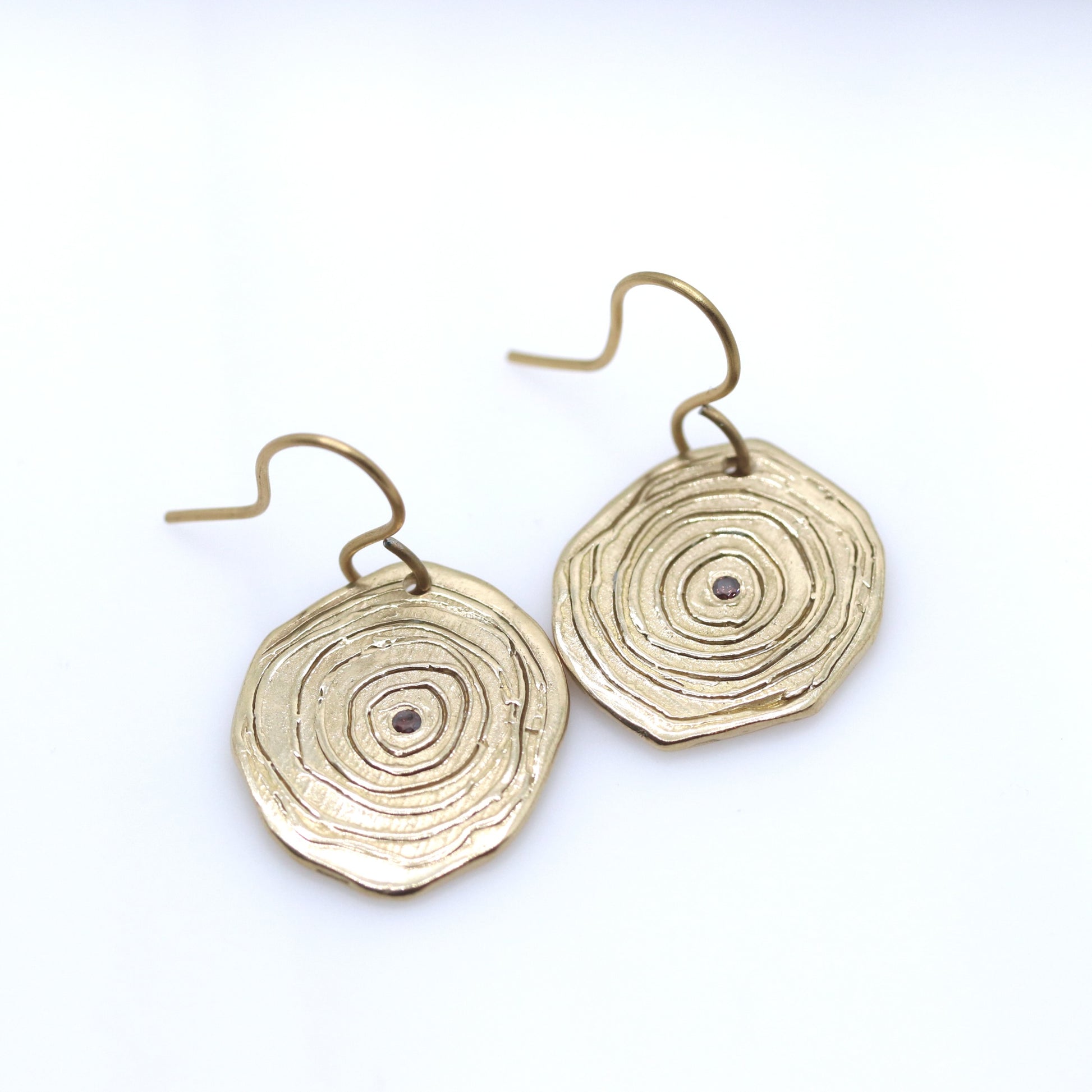 Gold circular earrings on a white background