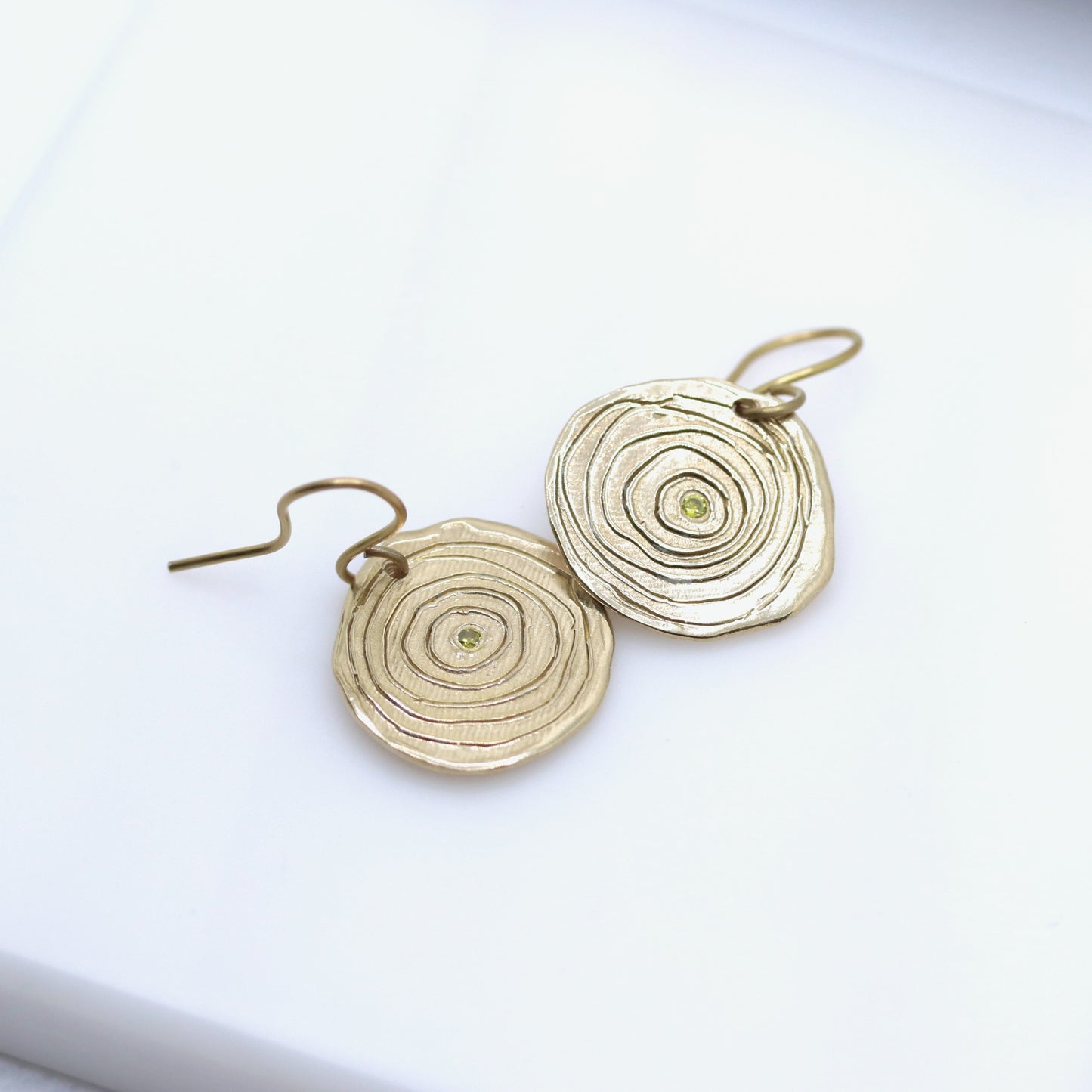 Gold circular earrings on a white background