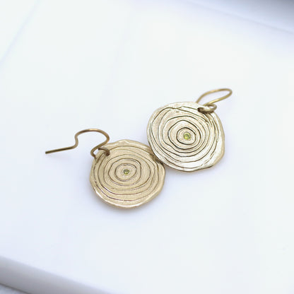 Gold circular earrings on a white background