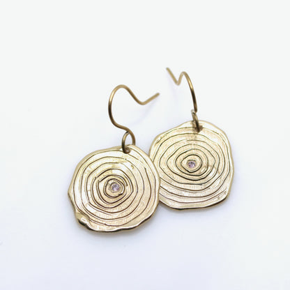 Gold circular earrings with a white background