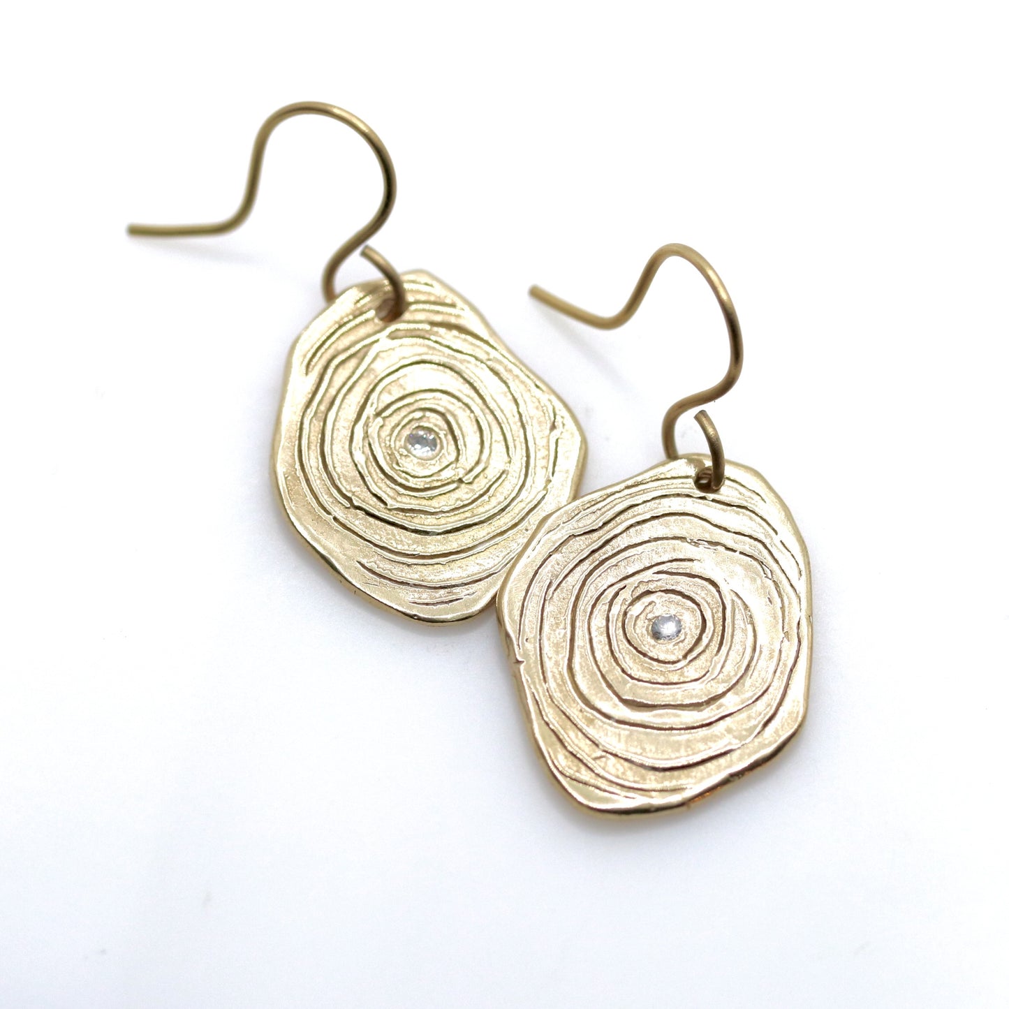 Gold circular earrings on a white background