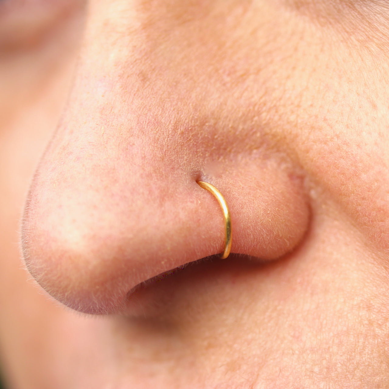 A nose wearing a 22 ct gold nose ring made by Fruit Bowl Studio, Wānaka, New Zealand.