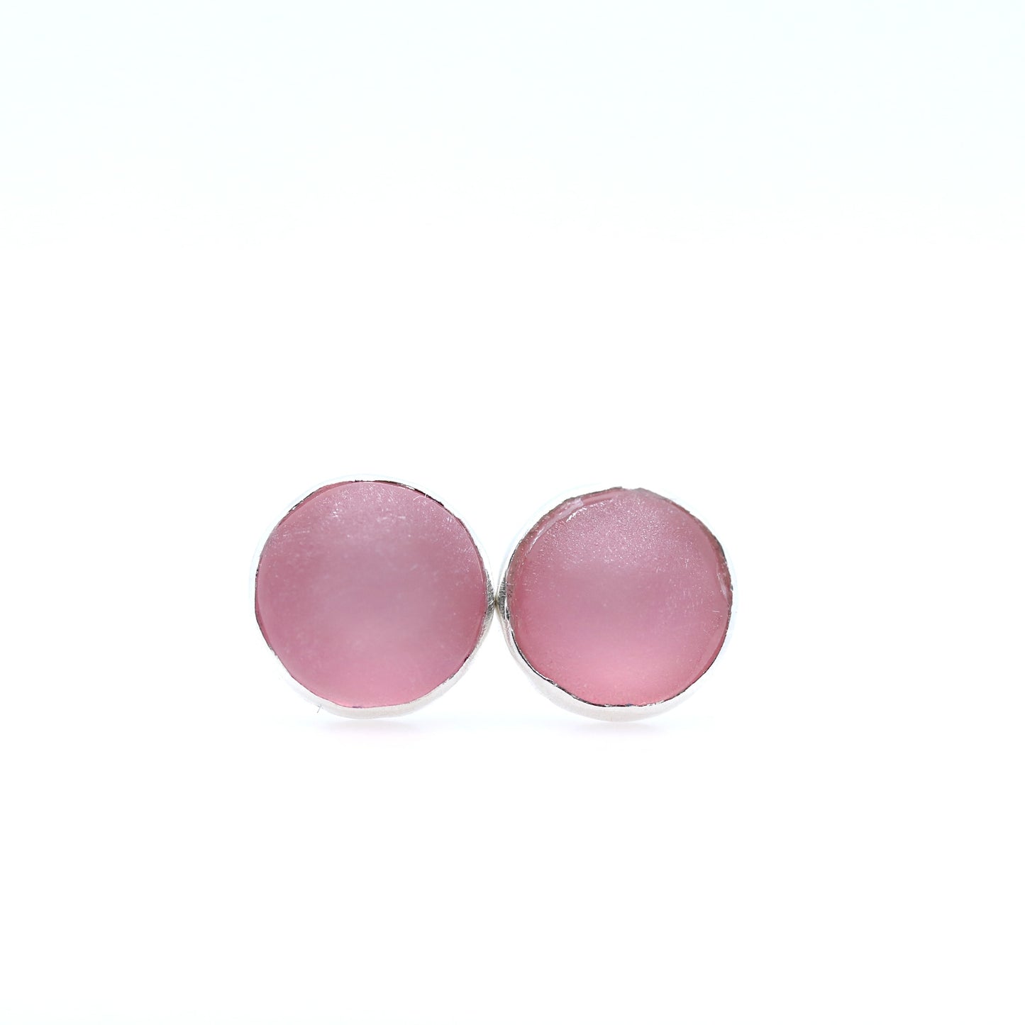 Pink round earrings on a white background