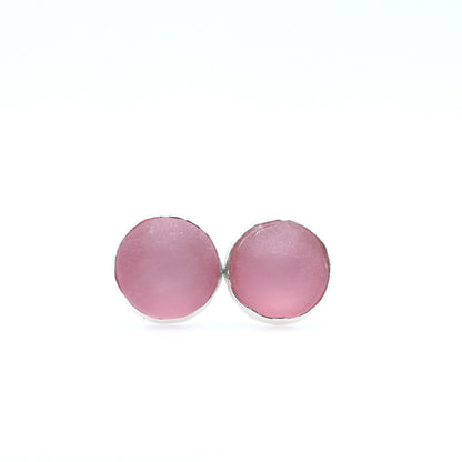 Pink round earrings on a white background
