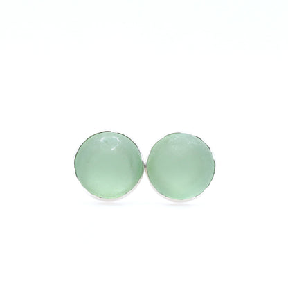 Pair of light green round earrings on a white background