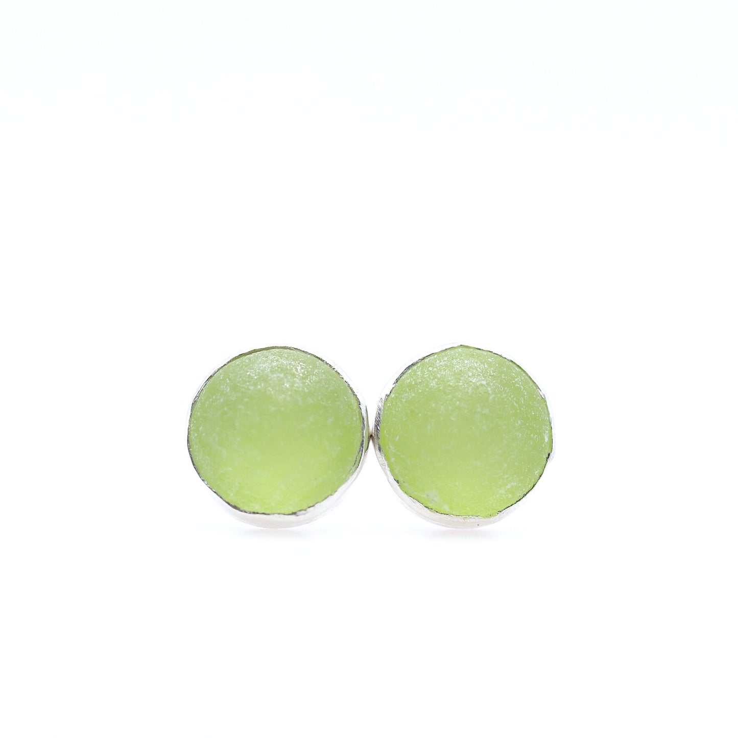 Pair of round green earrings on a white background