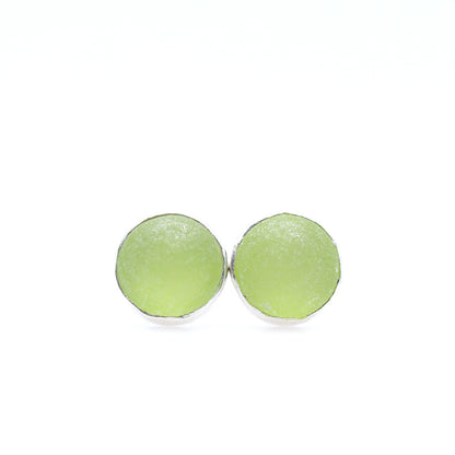Pair of round green earrings on a white background