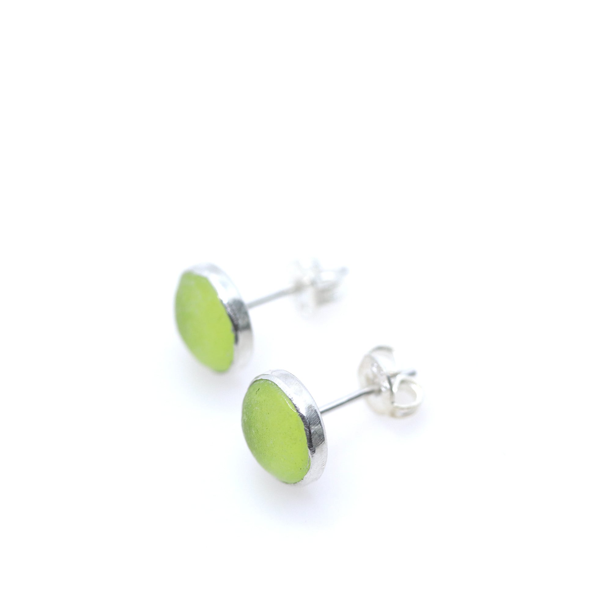 Pair of green round stud earrings on a white background