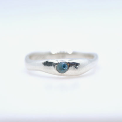 Silver ring with a blue gemstone on a white background