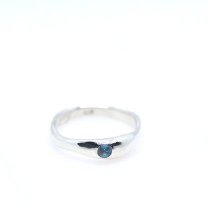 Silver ring with a blue gemstone on a white background