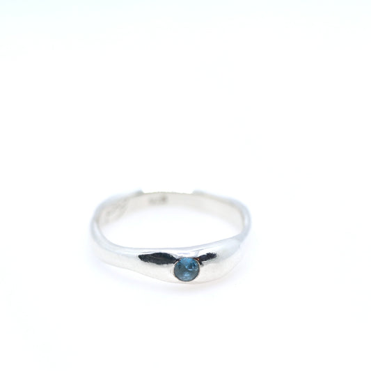 Silver ring with a blue gemstone on a white background