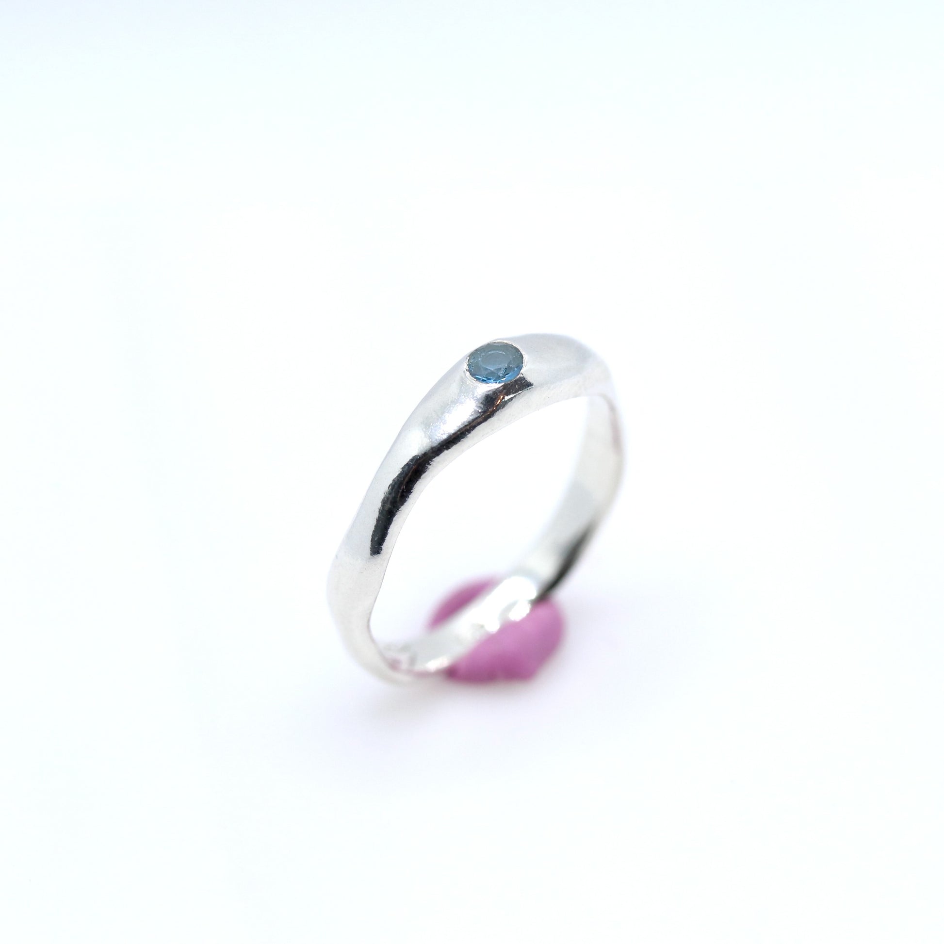 Silver ring with a blue gemstone on a white background