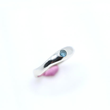 Silver ring with a blue gemstone on a white background