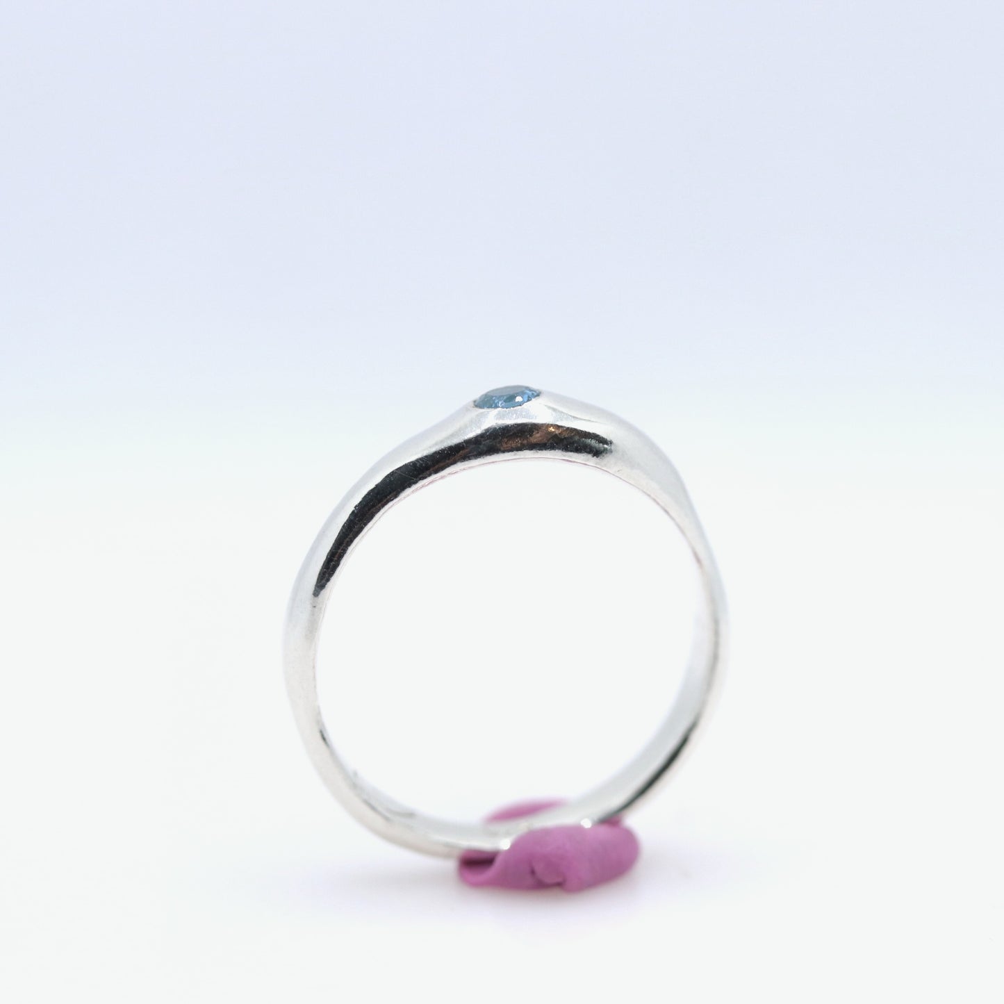 Silver ring with a blue gemstone on a white background