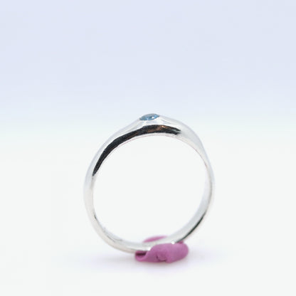Silver ring with a blue gemstone on a white background