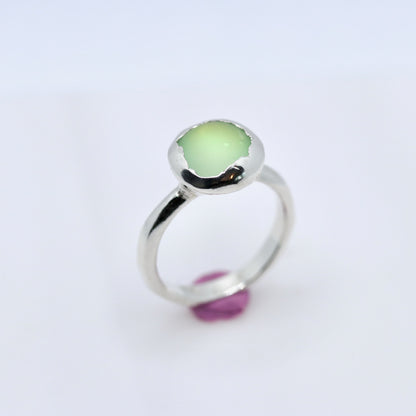 Silver ring with a green gemstone on a white background