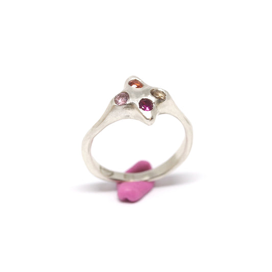 A silver ring with colourful gems. This ring was hand made in Wānaka, New Zealand by designer and jeweller Briar Hardy-Hesson.