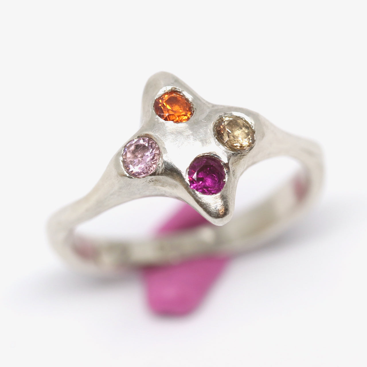 A silver ring with colourful gems. This ring was hand made in Wānaka, New Zealand by designer and jeweller Briar Hardy-Hesson.