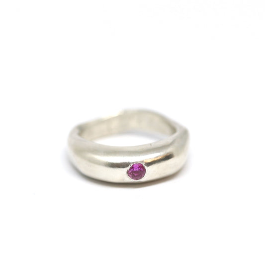 A curvy and chunky sterling silver pinky ring with one ruby pink cubic zirconia.