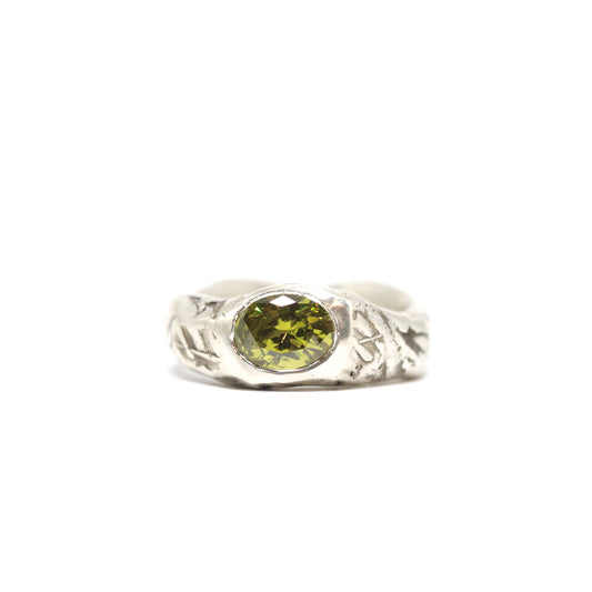 A curvy and chunky sterling silver with textured oxidised silver. This pattern was imprinted into the wax before casting. The ring is set with one oval olive green cubic zirconia.