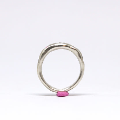 A sterling silver ring with five cubic zirconia in shades of pink and green.