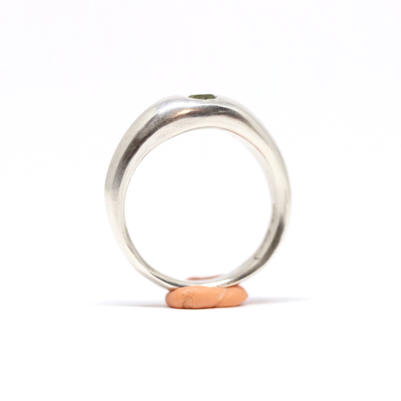 A sterling silver ring with one olive gem.