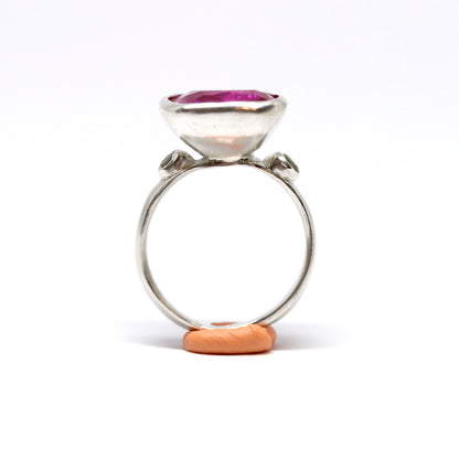 A big juicy pink cubic zirconia cocktail ring with two olive cubic zirconia on the shoulders.