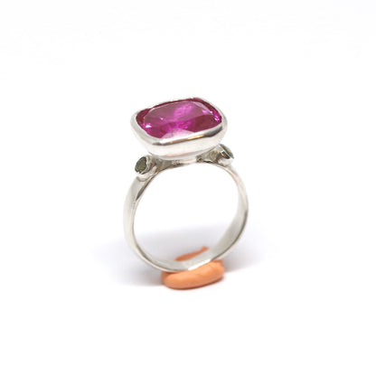 A big juicy pink cubic zirconia cocktail ring with two olive cubic zirconia on the shoulders.