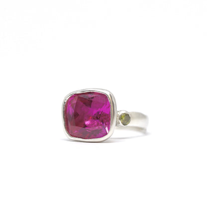 A big juicy pink cubic zirconia cocktail ring with two olive cubic zirconia on the shoulders.