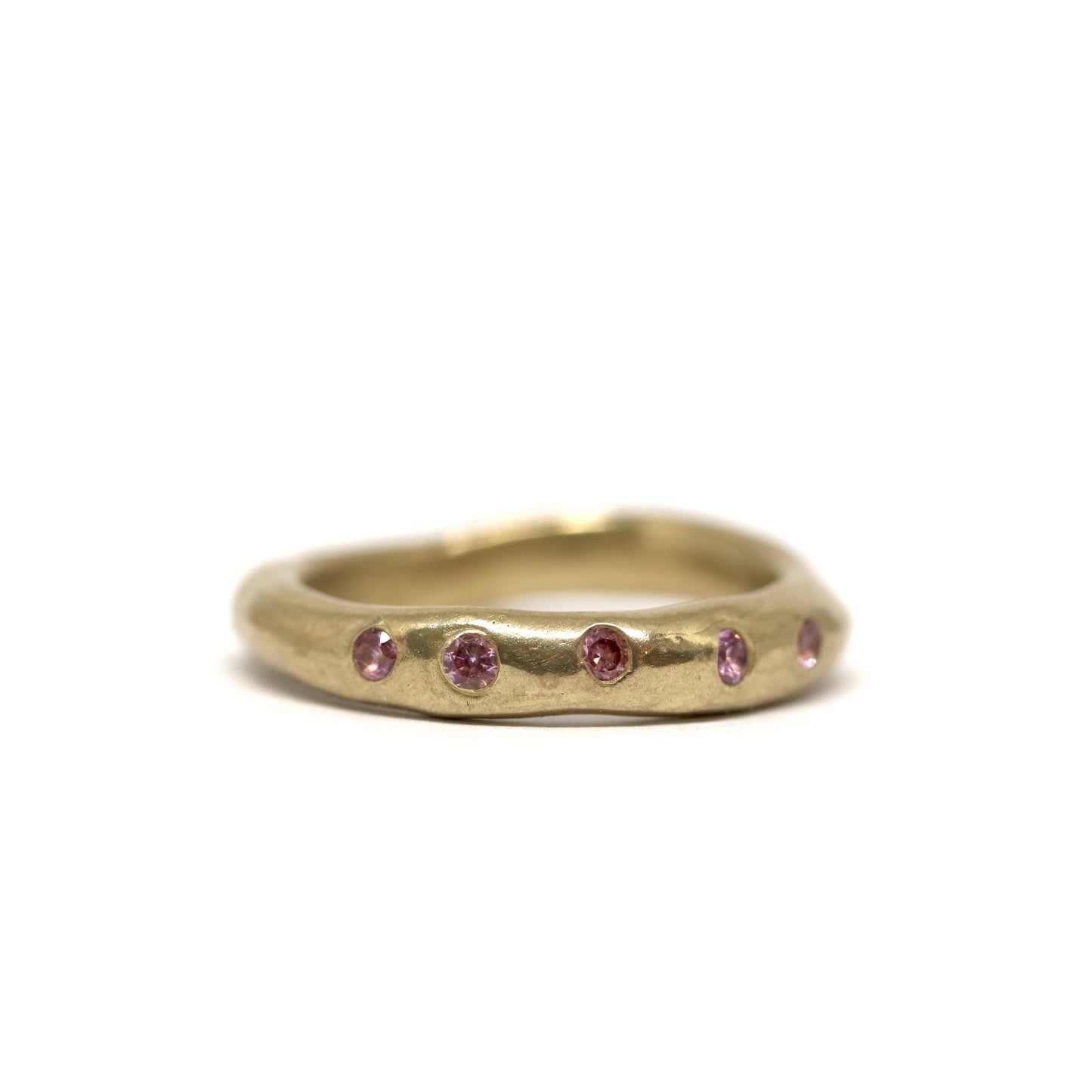 Bronze ring with embedded pink stones on a white background
