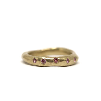 Bronze ring with embedded pink stones on a white background