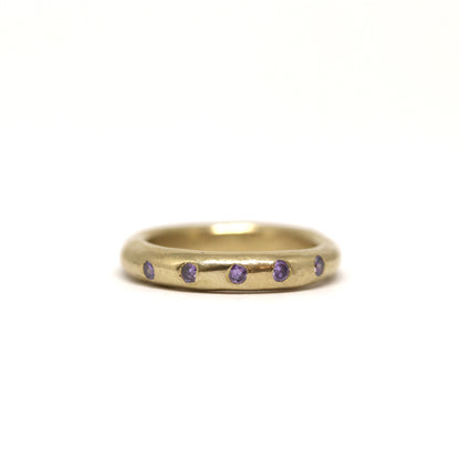 Bronze ring with purple gemstones on a white background