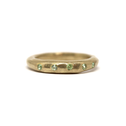 Bronze ring with green gemstones on a white background
