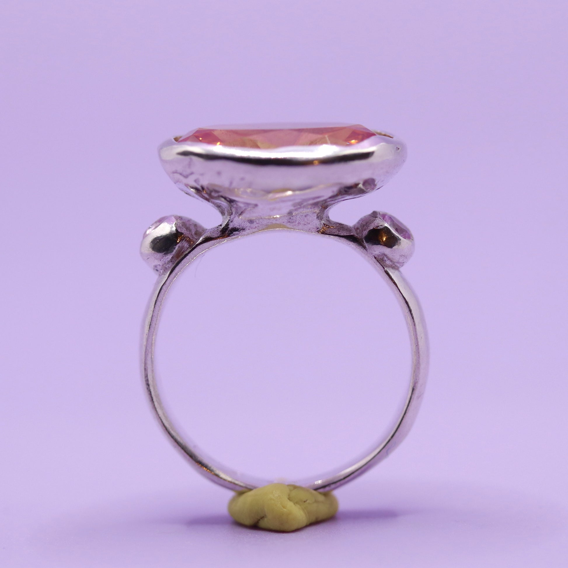 Silver ring with a large peach stone on a purple background. New Zealand made jewellery designer